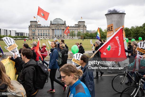 Demonstrators pass in front of the Reichstag building during a "Stop Coal" protest on June 24, 2018 in Berlin, Germany. While Germany has set...