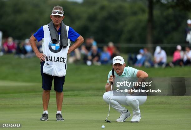 Matt Wallace of England and his caddy line up a putt on the 18th hole during the fourth round of the BMW International Open at Golf Club Gut...