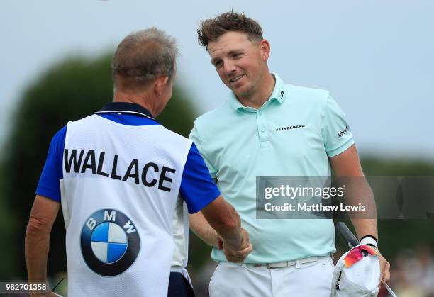 Matt Wallace of England shakes hands with his caddy on the the 18th hole during the fourth round of the BMW International Open at Golf Club Gut...