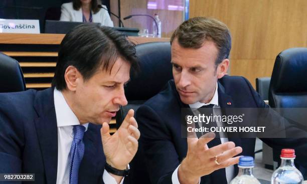 Italian Prime Minister Giuseppe Conte speaks with French President Emmanuel Macron alongside Greece's Prime Minister Alexis Tsipras during a summit...
