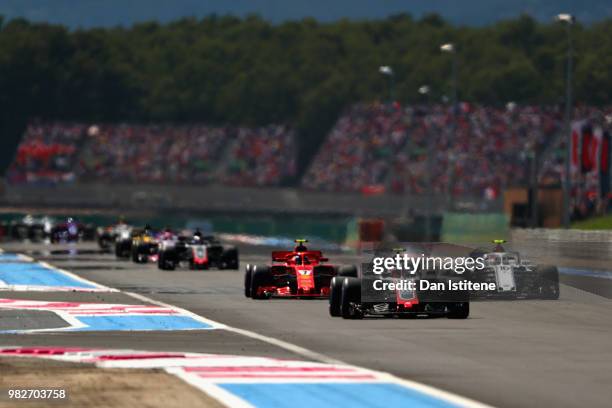 Kevin Magnussen of Denmark driving the Haas F1 Team VF-18 Ferrari leads Kimi Raikkonen of Finland driving the Scuderia Ferrari SF71H and Charles...