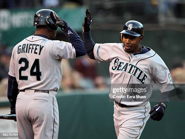 Chone Figgins of the Seattle Mariners is congratulated by Ken Griffey Jr. #24 after Figgins scored on a double by Casey Kotchman in the first inning...