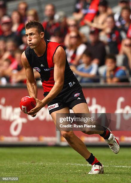 Cale Hooker of the Bombers handballs during the round two AFL match between the Essendon Bombers and the Fremantle Dockers at Etihad Stadium on April...