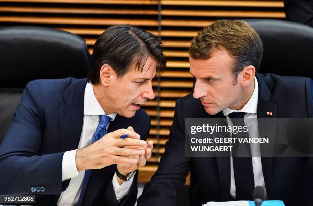 French President Emmanuel Macron speaks with Italian Prime Minister Giuseppe Conte during a round table meeting at an informal EU summit on migration...