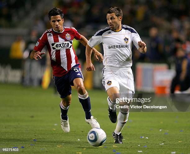 Dema Kovalenko of the Los Angeles Galaxy paces the ball on the attack on the left wing under pressure from Marcelo Saragosa of Chivas USA in the...