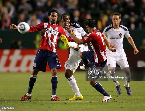 Maykel Galindo and Mariano Trujillo of Chivas USA defend the play of Alex Cazumba of the Los Angeles Galaxy in the first half during their MLS match...