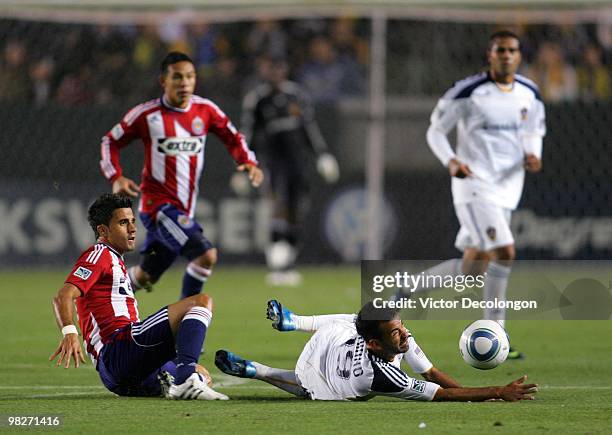 Marcelo Saragosa of Chivas USA tackles Juninho of the Los Angeles Galaxy in the first half during their MLS match at the Home Depot Center on April...