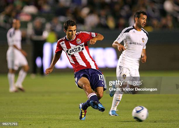 Jonathan Bornstein of Chivas USA pass the ball under pressure from Juninho of the Los Angeles Galaxy in the first half of their MLS match at the Home...