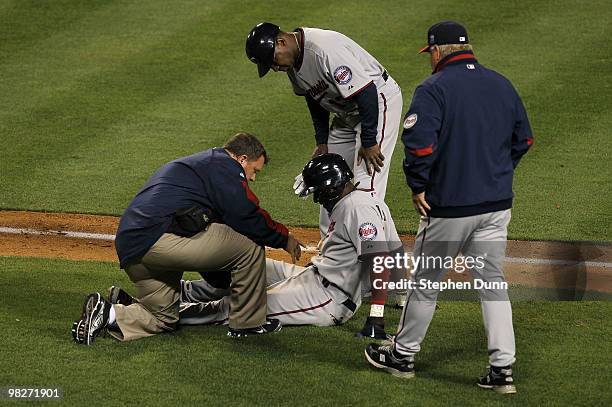 Orlando Hudson of the Minnesota Twins is examined by a trainer after being hit by a pitch from Kevin Jepsen of the Los Angeles Angels of Anaheim...