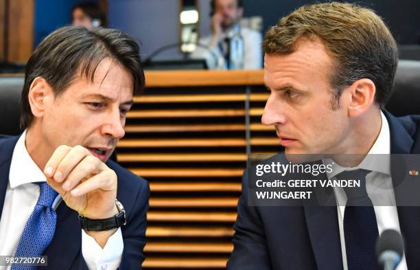 French President Emmanuel Macron speaks with Italian Prime Minister Giuseppe Conte during a round table meeting at an informal EU summit on migration...