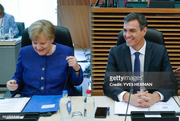 German Chancellor Angela Merkel speaks with Spanish Prime Minister Pedro Sanchez during a summit on migration issues at EU headquarters in Brussels...