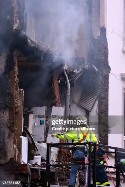 Dpatop - 24 June 2018, Wuppertal, Germany: The ruins of a house that exploded during the night are on the street. Two men look at the debris from a...