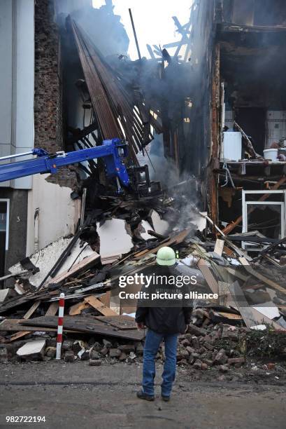 Dpatop - 24 June 2018, Wuppertal, Germany: An officer of the Criminal Investigation Department looks at the rubble of a house where there was an...