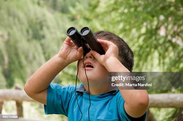 child playing with binoculars lens - looking through lens foto e immagini stock