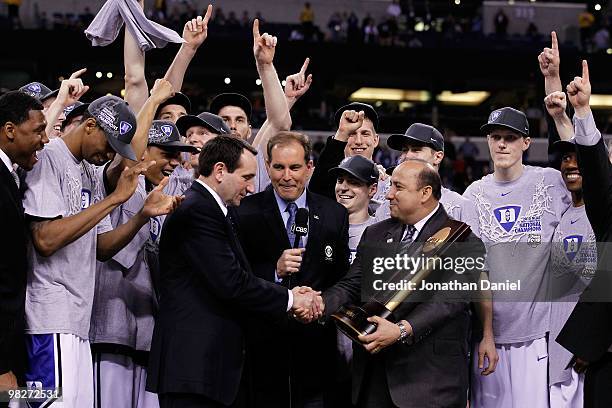 Head coach Mike Krzyzewski of the Duke Blue Devils receives the trophy as his players celebrate after they won 61-59 against the Butler Bulldogs...