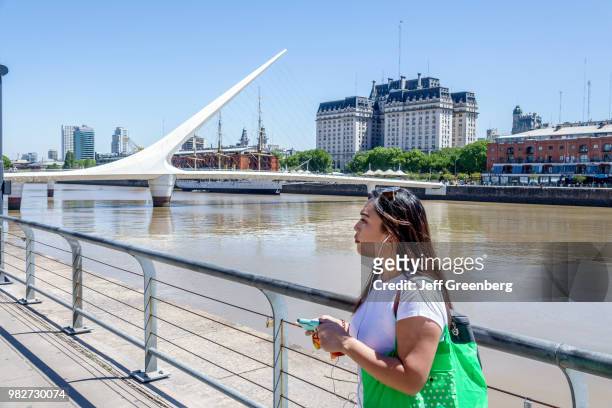 Woman standing on the Puente De La Mujer, pedestrian suspension swing bridge.