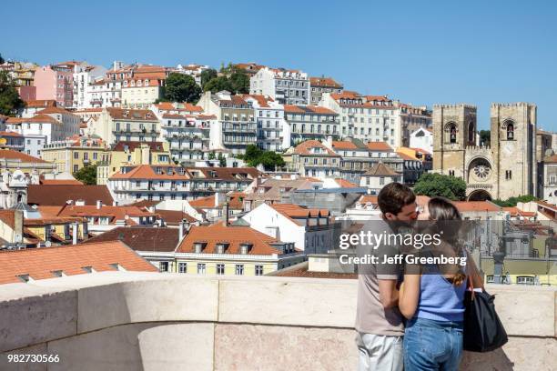 Portugal, Lisbon, Baixa, Chiado, historic district, couple kissing with city vew behind.
