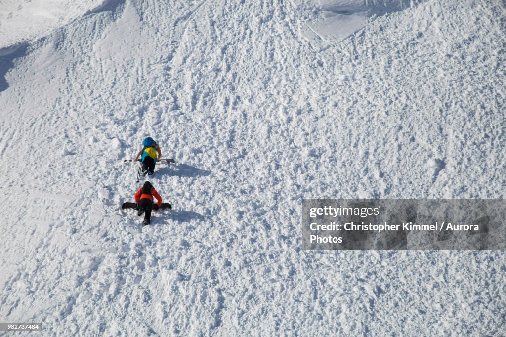 Backcountry skiers bootpacking up snowy hill, North Cascades National Park, Washington State, USA