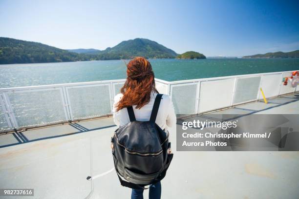 woman standing on ferry deck - diaper bag stockfoto's en -beelden