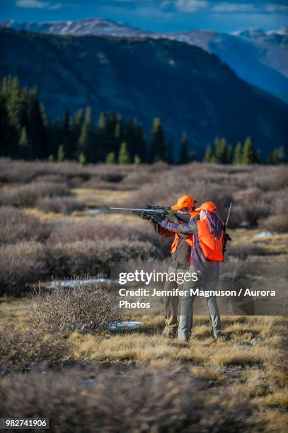 two hunters aiming rifle, colorado, usa - front range mountain range 個照片及圖片檔