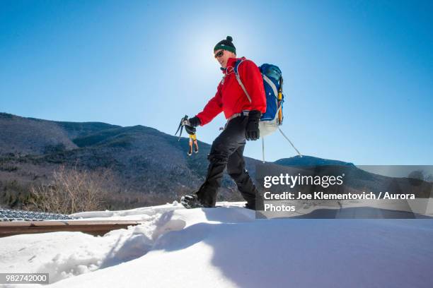 ice climber hiking on warm winter day, crawford notch, new hampshire, usa - crawford notch stock-fotos und bilder