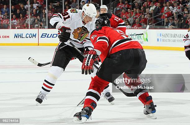 Marian Hossa of the Chicago Blackhawks skates against Colin White of the New Jersey Devils at the Prudential Center on April 2, 2010 in Newark, New...