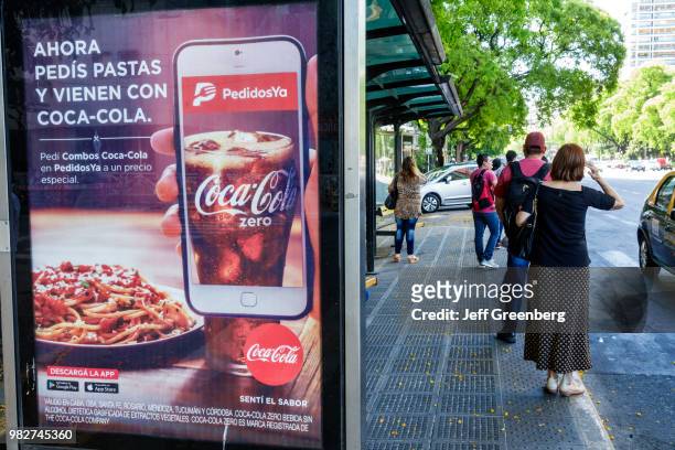 Argentina, Buenos Aires, Avenida del Libertador, bus stop shelter with Coke ad.