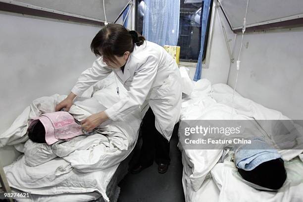 Woman takes care of two patients on the train carrying 60 rescued miners in a critical condition at the railway station April 06, 2010 in Hejin,...