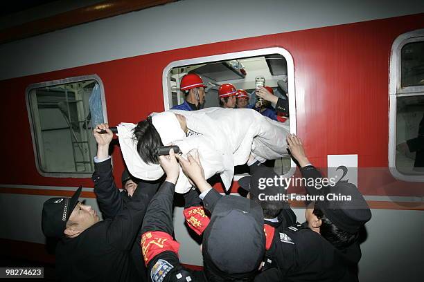 Railway workers carry a patient into the train carrying 60 rescued miners in a critical condition at the railway station April 06, 2010 in Hejin,...