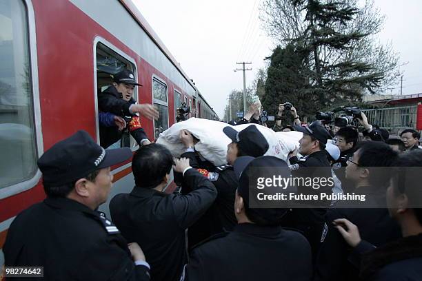 Railway workers carry a patient into the train carrying 60 rescued miners in a critical condition at the railway station April 06, 2010 in Hejin,...