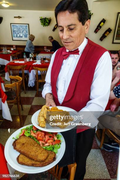 Argentina, Buenos Aires, Paseo de las Luces Restaurante Confiteria, waiter serving food.