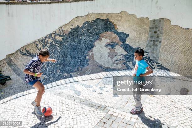 Portugal, Lisbon, Wall Of Amalia Rodrigues, kids playing soccer near tile mural .