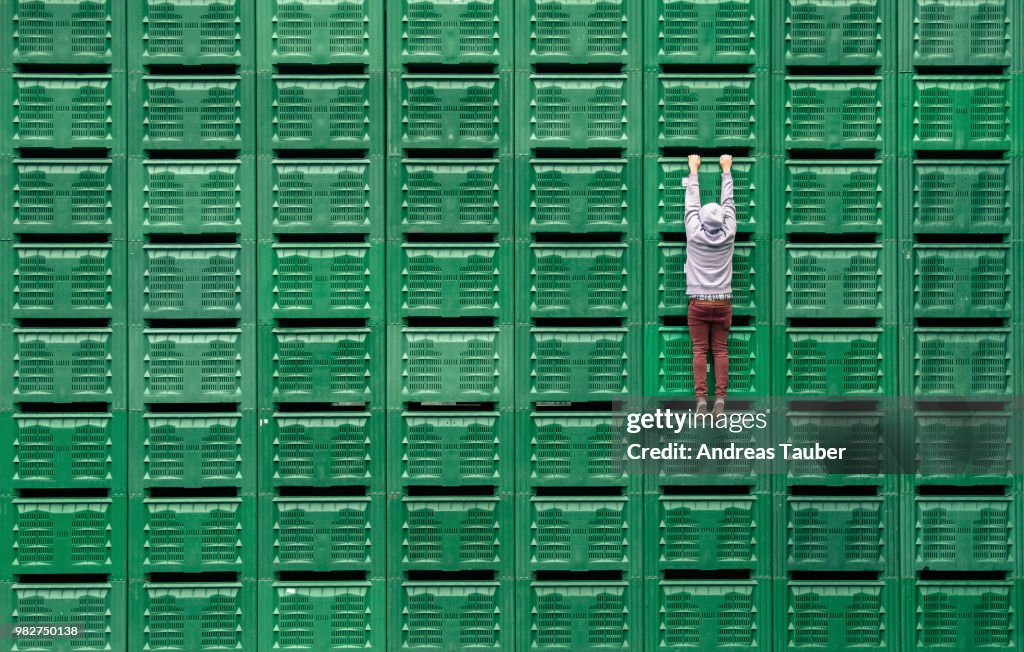 A man hanging from green servers.