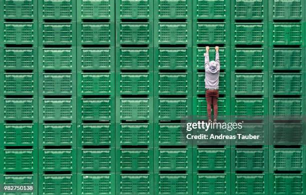 A man hanging from green servers.