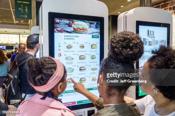 Portugal, Lisbon, Praca Dom Pedro, McDonald's, teens using self-service kiosk.