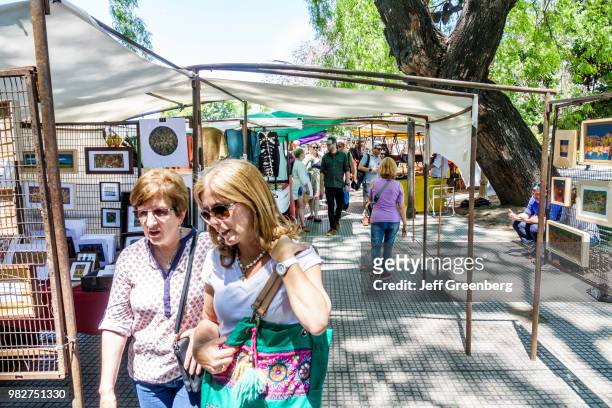 Women looking at art prints at the Craft Fair at Plaza Francia Feria, Artesanal Plaza Francia.