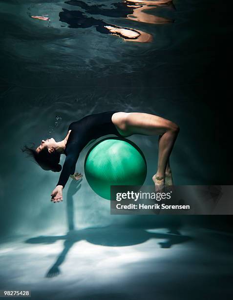 female gymnast with exercise ball underwater - henrik sorensen stock-fotos und bilder