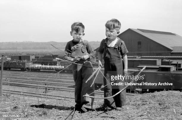 Two Young Boys Playing with Bows and Arrows near Railroad Yards, Dubuque, Iowa, USA, John Vachon for Farm Security Administration, April 1940.