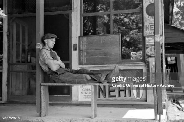 Man Resting in front of General Store, Blankenship, Martin County, Indiana, USA, Arthur Rothstein for U.S. Resettlement Administration, May 1938.