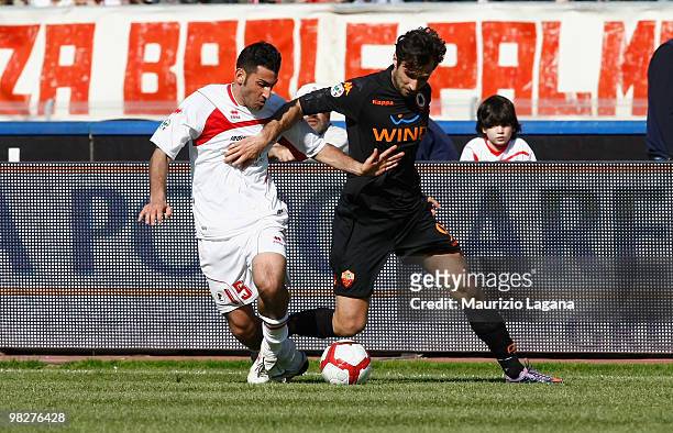 Nicola Belmonte of AS Bari battles for the ball with Mirko Vucinic of AS Roma during the Serie A match between AS Bari and AS Roma at Stadio San...