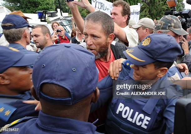 South African police try to keep blacks and whites apart as race tensions flared when a white woman sprayed water as blacks sang the national anthem...