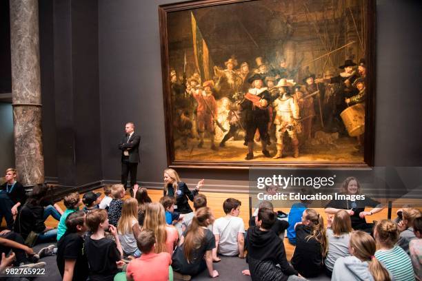 Dutch students learning about Rembrandt's 'The Night Watch' in the Rijks Museum, Amsterdam, Netherlands.
