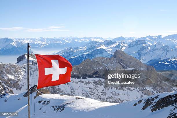 switzerland flagg over swiss alps - switzerland snow stock pictures, royalty-free photos & images