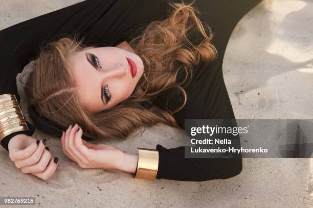 young woman lying on sand, kyiv, ukraine - photo shoot makeup stock pictures, royalty-free photos & images