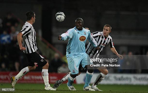 Adebayo Akinfenwa of Northampton Town looks for the ball with Michael Leary and Oliver Lancashire of Grimsby Town during the Coca Cola League Two...