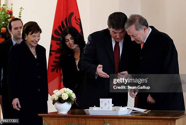 Albanian President Bamir Topi explains a passage he wrote in the official guestbook to German President Horst Koehler as German First Lady Eva Luise...