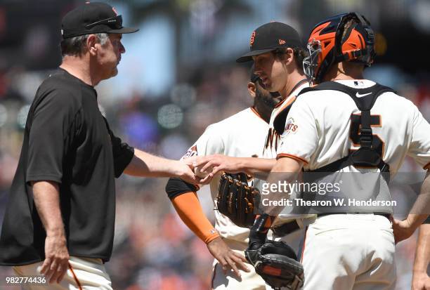 Manager Bruce Bochy of the San Francisco Giants takes the ball from starting pitcher Derek Holland taking Holland out of the game against the Miami...
