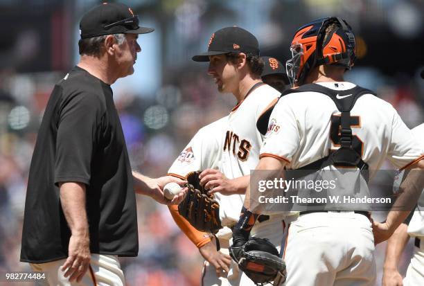 Manager Bruce Bochy of the San Francisco Giants takes the ball from starting pitcher Derek Holland taking Holland out of the game against the Miami...