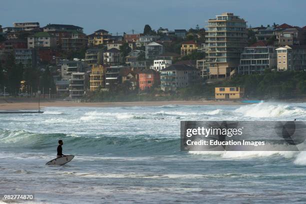 Surfers at Manly beach on a stormy day. Northern suburbs, Sydney, NSW, Australia.