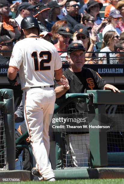 Joe Panik of the San Francisco Giants is congratulated by manager Bruce Bochy after Panik scored against the Miami Marlins in the bottom of the six...